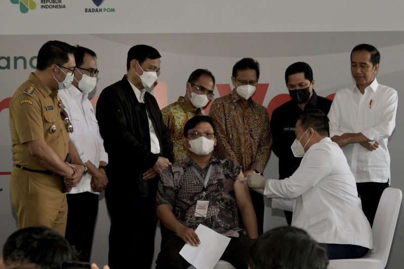 Presiden Jokowi dan sejumlah pejabat sedang menyaksikan penyuntikan pertama vaksin Indovac